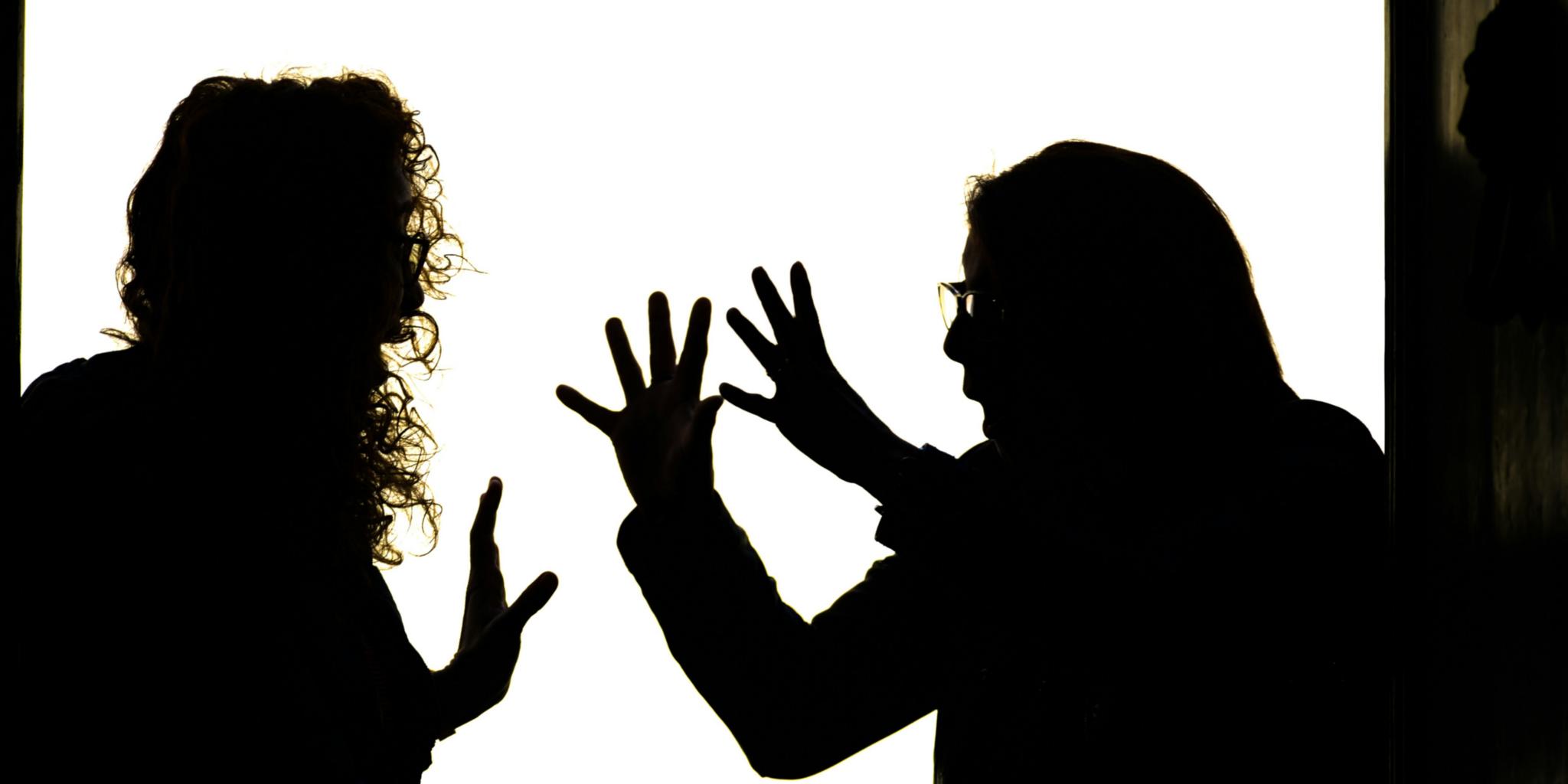 Silhouettenhafte Figuren liefern sich einen hitzigen Streit.